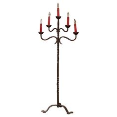 an iron candelabra with five red candles