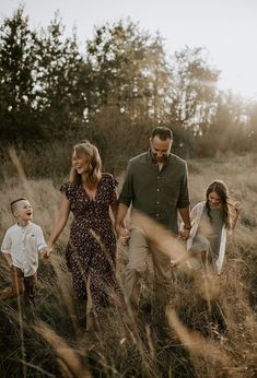 a family walking through tall grass holding hands