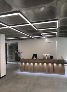 an empty office with lights on the ceiling