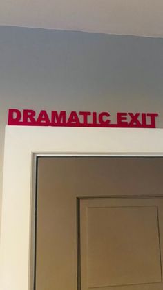 an exit sign on the side of a door with red lettering above it that says dramatic exit