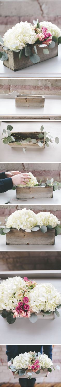 flowers are placed on the side of a wooden box with white and pink flowers in it