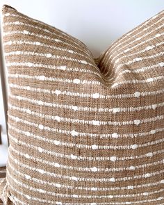 a brown and white striped pillow sitting on top of a wooden table