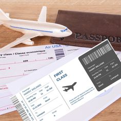 an airplane ticket sitting on top of a wooden table next to a brown leather wallet