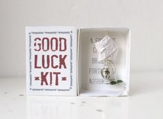 a small white box with a piece of paper in it that says good luck kit