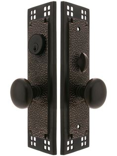 two black door handles with brown knobs on each side and one has an ornate design