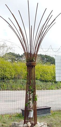 a tall metal sculpture sitting on top of a lush green field