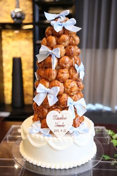 a wedding cake made to look like a tree with white bows and hearts on it