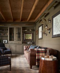 a living room with couches, chairs and deer head mounted on the wall above them