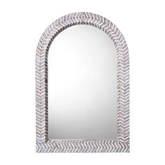 a mirror that is sitting on top of a wall with an arrow design in the middle