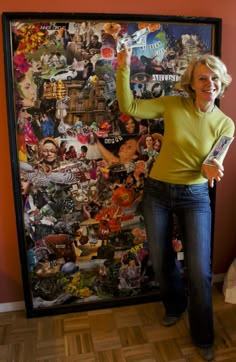 a woman standing in front of a large poster with many pictures on it's side