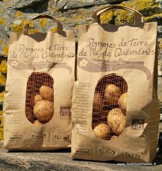 two bags of potatoes sitting next to each other on a wooden table in front of a stone wall