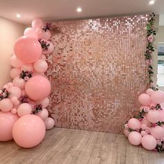 balloons and flowers are arranged on the floor in front of a wall with sequins