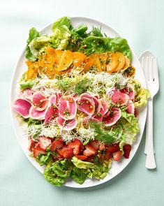 a white plate topped with a salad covered in lots of veggies