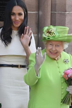 the queen waves as she stands next to her mother, who is wearing a green hat and dress