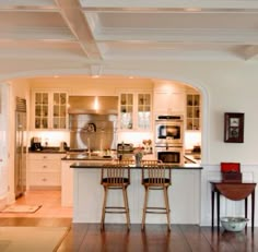 an open kitchen and living room with hardwood floors