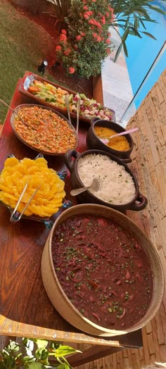 a table filled with lots of different types of food on top of wooden trays