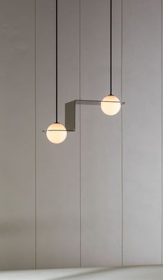 three light fixtures hanging from the ceiling in a room with white walls and flooring