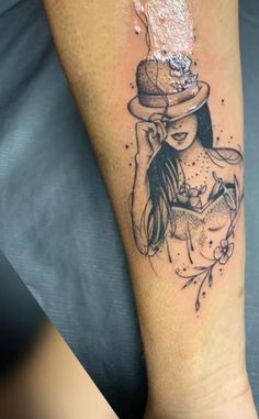 a woman with a hat on her head is sitting in front of a tattoo design