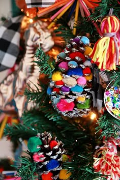 a christmas tree with colorful ornaments and decorations on it's branches in the shape of pine cones