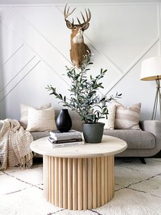 a living room filled with furniture and a deer head mounted on the wall above it