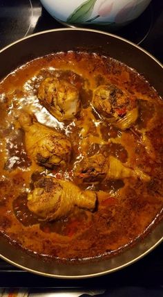 a pan filled with food sitting on top of a stove covered in gravy