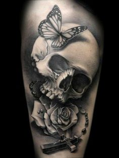 a black and white tattoo with a skull, roses and a butterfly on the arm