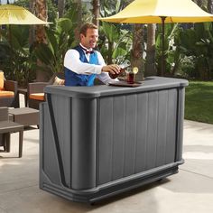 a man sitting at an outdoor bar with umbrellas in the backgroung