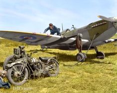 two men working on an old airplane in the grass with another man sitting next to it