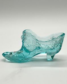 a glass shoe sitting on top of a white table