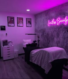 a bed room with a neatly made bed next to a neon sign on the wall