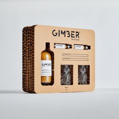 an empty bottle and two glasses in a cardboard box with labels on it that say gimber