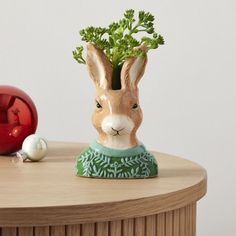 a rabbit head planter sitting on top of a table next to an ornament