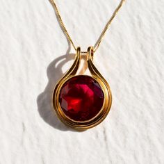 Gold Ruby Pendant set with a Created Ruby in a flawless diamond cut & bright red color, at 18mm (20 Carats).  Gold Vermeil: 18k Gold over Solid 925 Sterling Silver ☞ made to last. Matching Ring & Earrings - please ask me Details : ♥ Each item comes in a cute GIFT BOX ✓ ♥ GUARANTEE on all materials ✓ ♥ 18k Gold over Solid 925 Sterling Silver ✓ ♥ Each stone set professionally - WellMade Craftmanship ♕ ♥ More Beautiful jewellery on www.etsy.com/shop/AdinaStone ☜ ✉ Shipping by Royal Mail ✉ Tracked Shipping Option - worldwide tracking - choose at checkout: U.K. 1 Day delivery ! USA & Worldwide ✈ 5-7 Days Standard Shipping speed: U.K. ✈ 2-3 days USA ✈ 5-10 days Europe (all countries) ✈ 5-7 Days Rest of the world ✈ 8-18 Days *as stated by Royal Mail Fine Quality Jewelry ♥ Handmade in Europe ♥ Art Ruby Pendant Set, Statement Necklace Gold, Flawless Diamond, Ruby Pendant, Gold Statement Necklace, Red Necklace, Necklace Statement, Matching Rings, Round Pendant