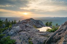 the sun is setting over some rocks in the mountains