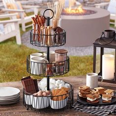 a table topped with plates and cups next to a fire place filled with food on top of a wooden table