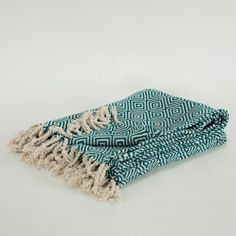 a blue and white blanket folded on top of each other with fringes around the edges