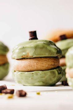 green frosted doughnuts stacked on top of each other with chocolate chips around them