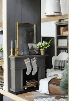 a living room filled with furniture and a fire place next to a christmas tree in front of a fireplace