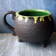 a brown and green pot sitting on top of a wooden table