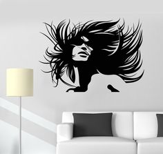 a living room with a white couch and black wall decal depicting a woman's hair blowing in the wind