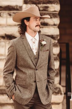 a man in a suit and cowboy hat