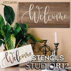 the welcome sign is next to a potted plant and candle holder on a table