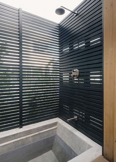 an outdoor bathtub with wooden slats on the wall