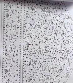 an intricately designed paper with black and white designs on the side, in front of a