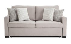 a couch with pillows on top of it and two sides facing the same direction, in front of a white background