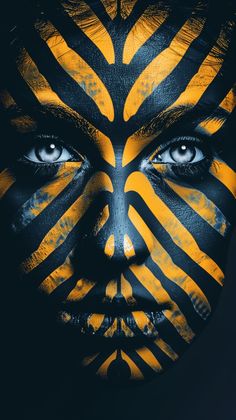 a woman's face painted in yellow and black with zebra stripes on her face