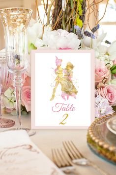 a table is set with flowers and silverware for a princess themed birthday party at home