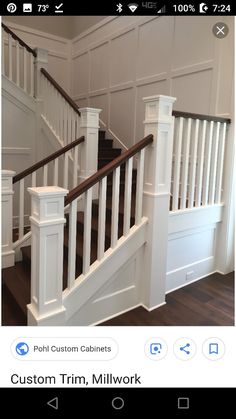 a white staircase with wooden handrails and wood flooring