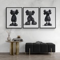 two black and white mickey mouse pictures hanging on the wall next to a coffee table