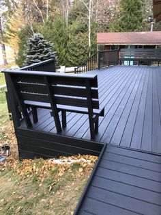 a black bench sitting on top of a wooden deck